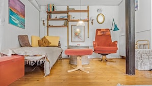 A cozy room with a bed, a red armchair, a small table, and a bookshelf. - 2 bedroom cozy home in Faxe (Faxe)