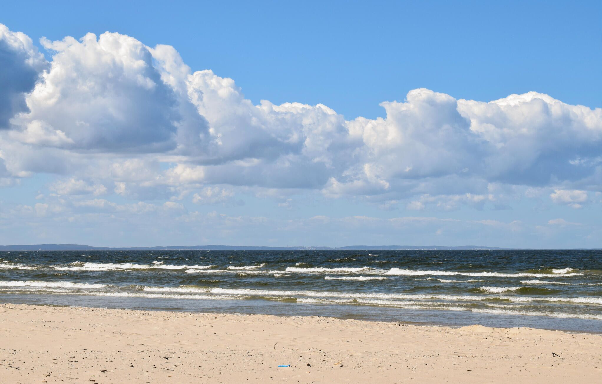Une plage avec des vagues et un ciel dégagé.