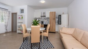 A compact living space with a dining area, kitchenette, and a sofa. - Amazing apartment in Stara Baska with WiFi (Stara Baska)