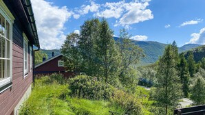 A rustic cabin with a view of a mountain range and lush greenery. - 2 bedroom pet friendly home in Haddal (Haddal)