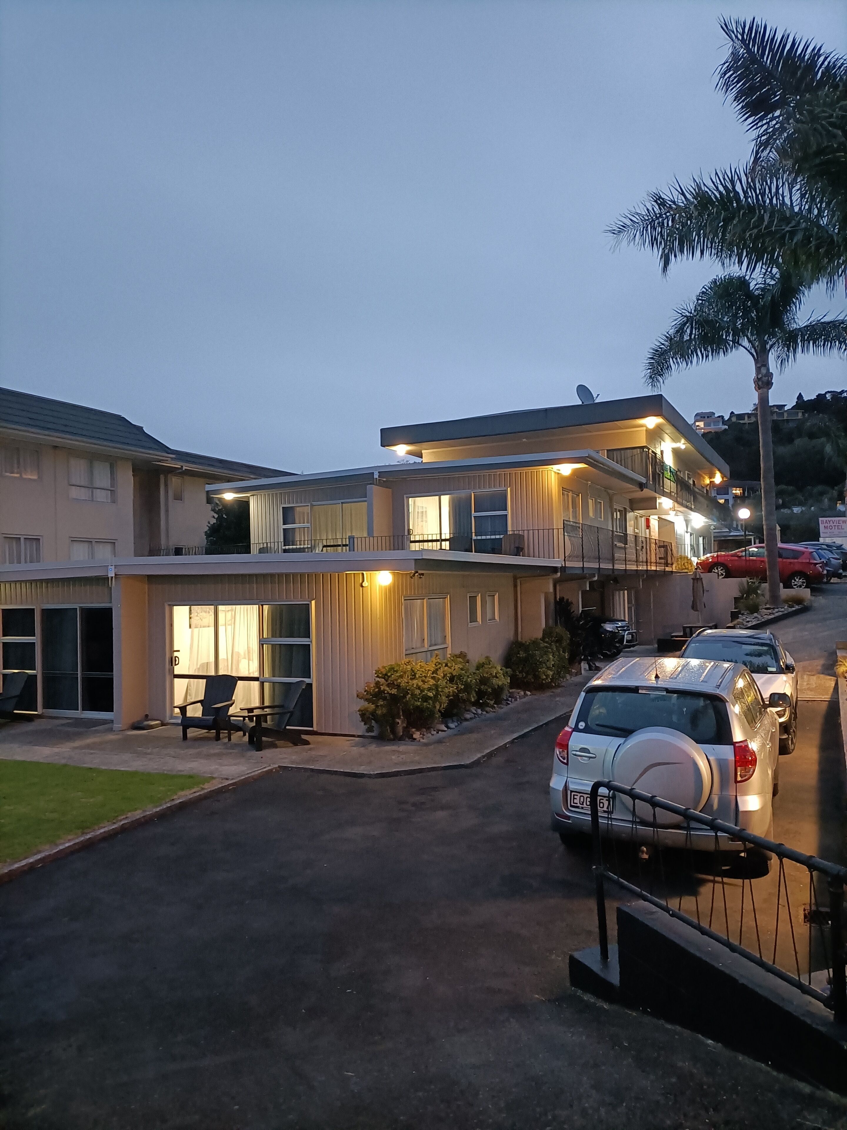 A modern hotel with a spacious outdoor seating area, a covered patio, and a parking lot.
