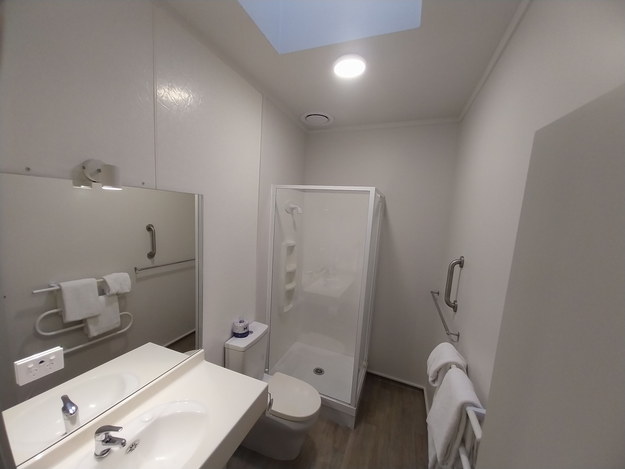 A compact bathroom with a shower, toilet, and sink.
