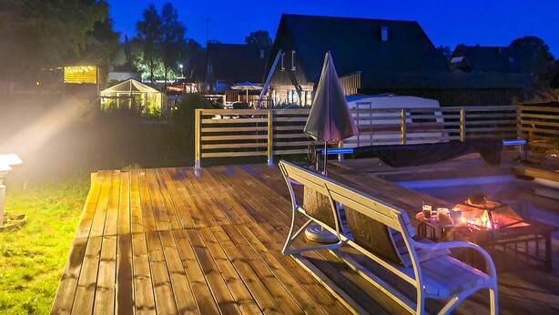 A wooden deck with a table and chairs, a fire pit, and a tent. - Lovely home in Perstorp (Perstorp)