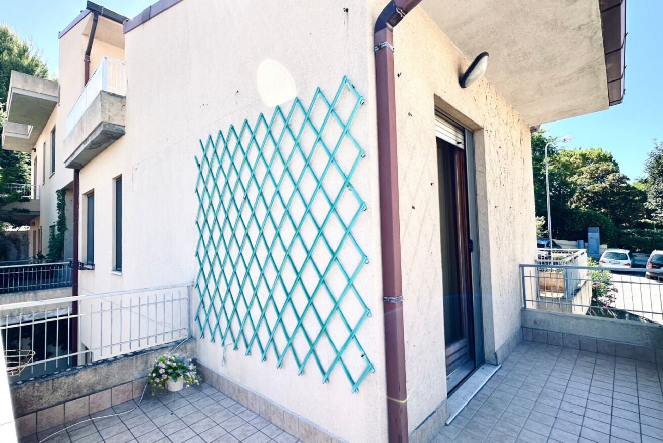 A building with a balcony, a lattice fence, and a door.