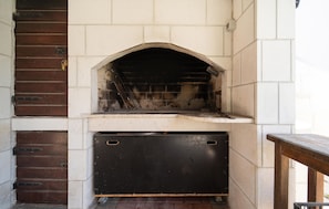 A brick oven with a metal door, a metal ladder, and a white tiled wall. - Nice home in Kozino with sauna (Kozino)