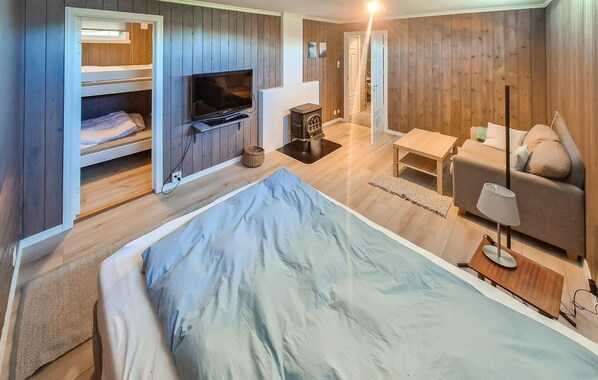 A bedroom with a bed, a TV, a sofa, and a small table. - Beach front home in ølve with WiFi (Ølve)