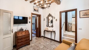 A living room with a television, wooden dresser, and a sofa. - 2 bedroom pet friendly home in Todi (Todi)