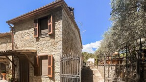 A stone building with wooden shutters, a metal gate, and a clear blue sky. - 2 bedroom pet friendly home in Todi (Todi)