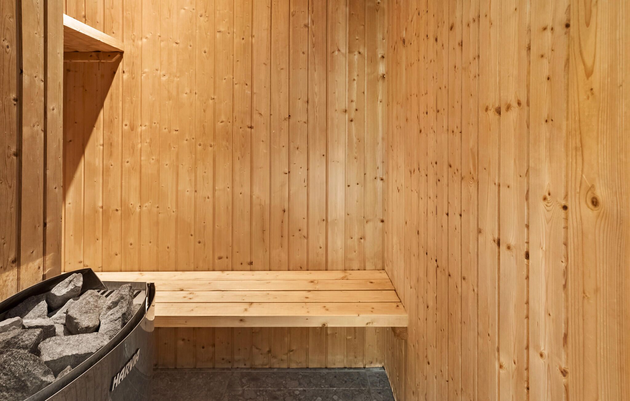 Una sauna con paredes de madera y un banco.
