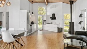 A modern kitchen with white cabinets, stainless steel appliances, and a large window. - Awesome home in Væggerløse with sauna (Væggerløse)