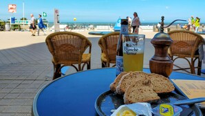 A table with bread, butter, and a bottle of Blanche de Namur beer at a beachside cafe. - 3 bedroom nice apartment in Oostende (Oostende)