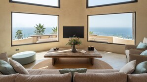 A room with a large wooden table, two sofas, and a TV. There are large windows with ocean views. - Villa 'Rocca' with Sea View, Wi-Fi and Air Conditioning (La Herradura)