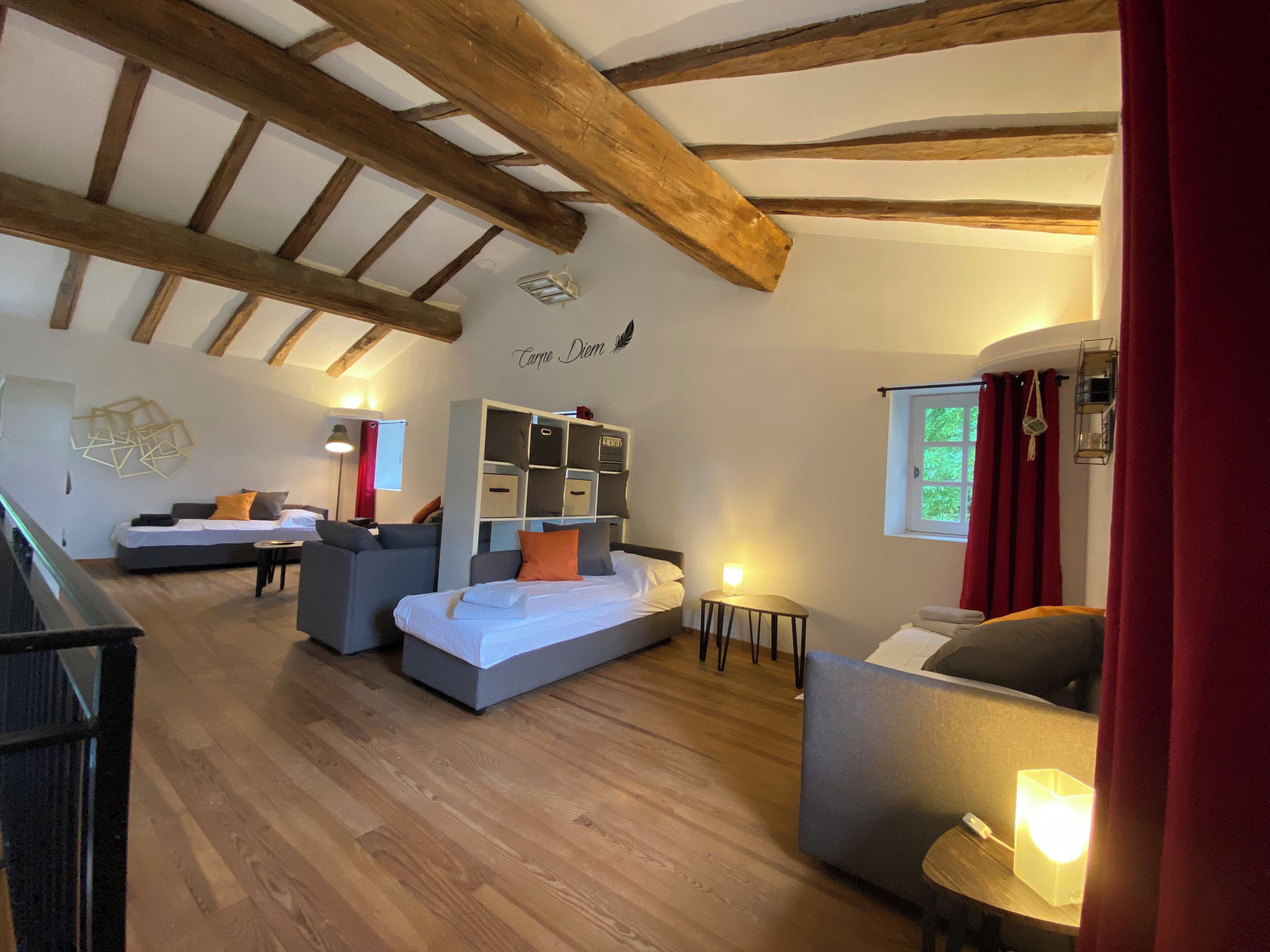 Um quarto acolhedor com uma cama, dois sofás, uma mesinha e um móvel embutido.