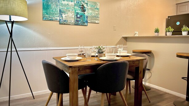 A dining area with a wooden table set for four, black chairs, and a floor lamp. - Worker friendly, cozy, great location, quiet, full kitchen, WiFi,  (Sherman)
