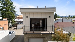 A two-story building with a garage at the bottom and a balcony on the upper floor.