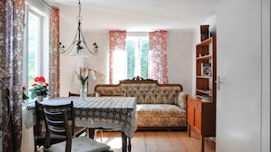 A dining area with a table and chairs, a sofa, and a bookshelf. - Cozy home in Kristinehamn with WiFi (Kristinehamn)