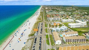 An aerial view of a coastal area with a beach, buildings, and a road. - Spring Discounts! Pool & Hot tub.1st Fl. (Miramar Beach)