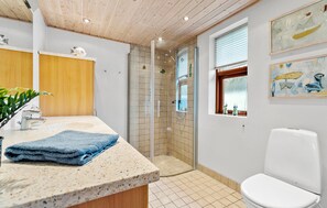 A modern bathroom with a shower, toilet, and sink. - 2 bedroom nice home in Juelsminde (Juelsminde)