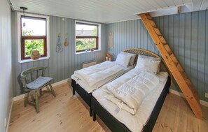 A bedroom with a bed, a chair, and a window. - 2 bedroom nice home in Juelsminde (Juelsminde)