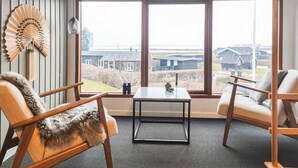 A room with a large window, two chairs, a small table, and a decorative fan. - 2 bedroom nice home in Juelsminde (Juelsminde)