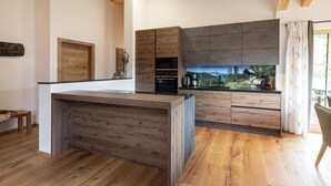 Una cocina moderna con armarios de madera, horno empotrado y una isla grande.