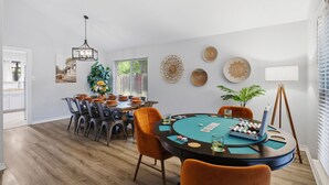 Un espace repas comprenant une table ronde, des chaises et un lustre.