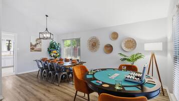 Un espace repas comprenant une table ronde, des chaises et un lustre.