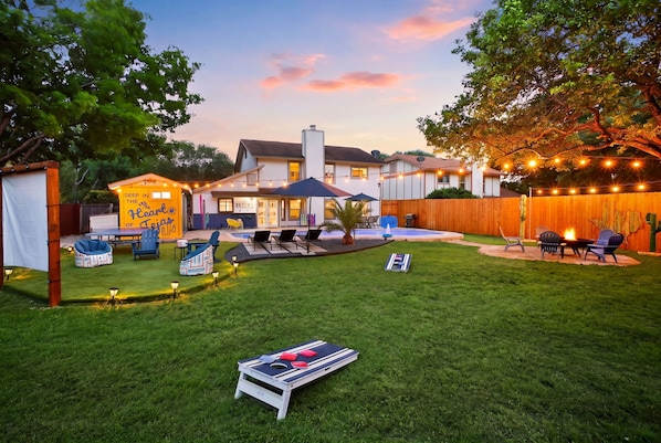 A backyard with a barbecue area, outdoor seating, and a play area.