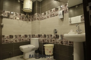 Une salle de bain comprenant des toilettes, un bidet, un lavabo et un porte-serviettes.
