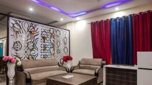 Una sala de estar moderna con un juego de sofá, una mesa de centro y un panel decorativo en la pared.