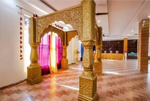 An ornate archway with intricate carvings, leading to a room with a patterned floor. - Hotel Roop Mandi (Manali)