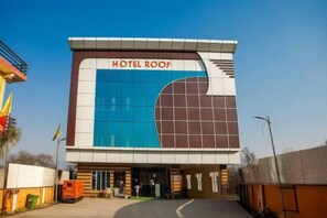 A modern hotel building with a prominent sign reading "HOTEL ROOP". - Hotel Roop Mandi (Manali)