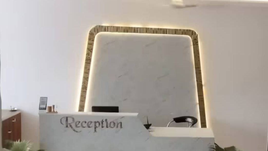 Un mostrador de recepción con un cartel que dice "Reception" y un diseño moderno y minimalista.