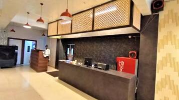 A reception area with a counter, a wooden cabinet, and a red Coca-Cola refrigerator.