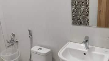 A bathroom with a toilet, bidet, and sink.
