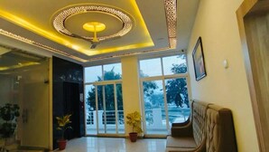 A spacious room with a large window, a ceiling light fixture, and a sofa. - Hotel Lakeview Chhatarpur (Chhatarpur)
