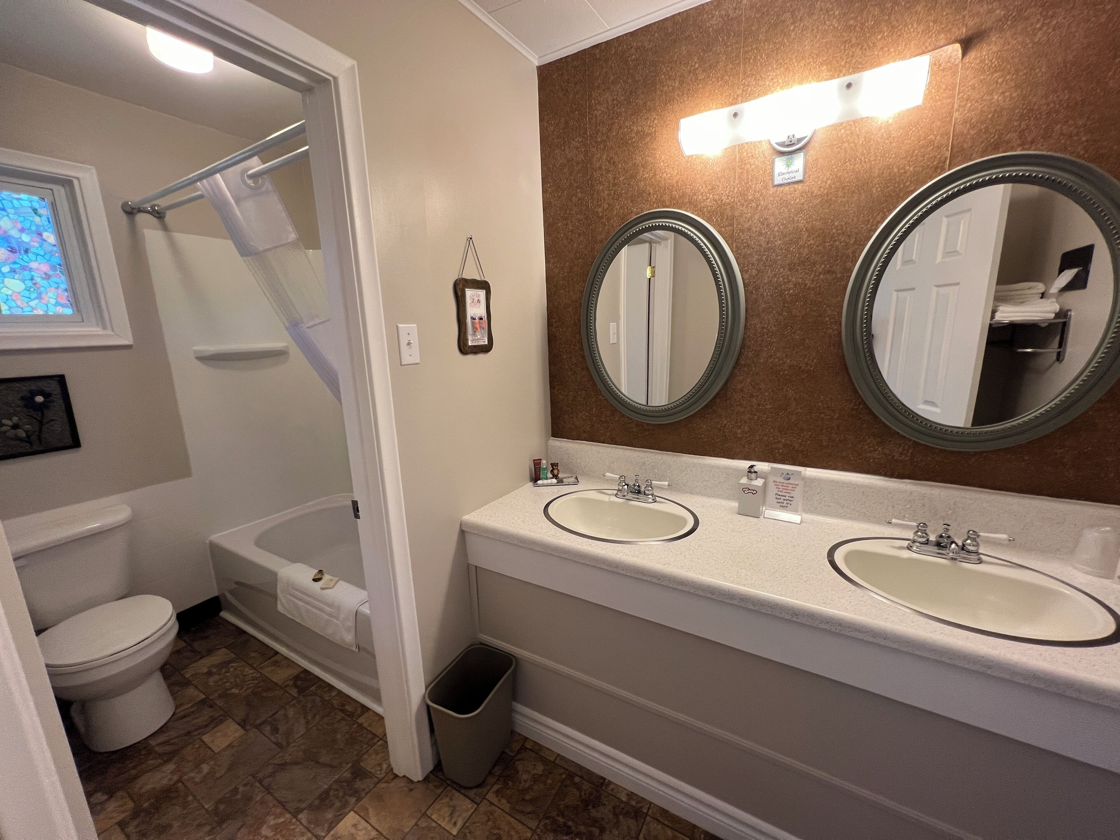 A bathroom with two sinks, a shower, and a toilet.