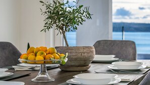 A dining table set with plates, cutlery, and a bowl of oranges. - Silencia by Interhome (Maslenica)