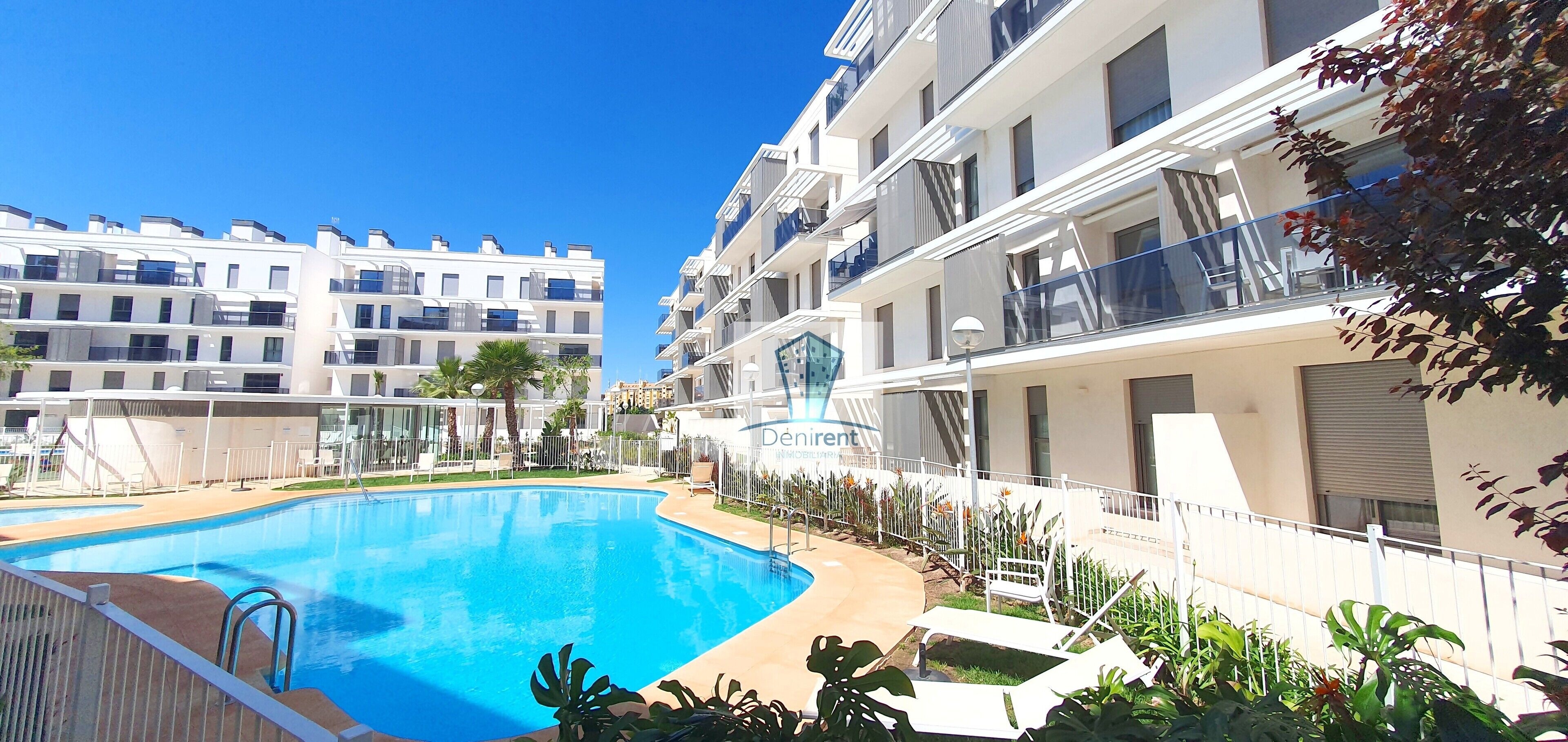 Un hôtel moderne doté d’une piscine, de nombreux balcons et d’un jardin bien entretenu.