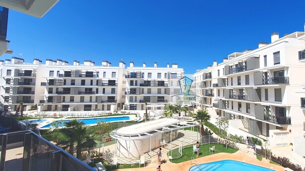 Um complexo de apartamentos moderno com várias varandas, piscina e terraço no telhado.