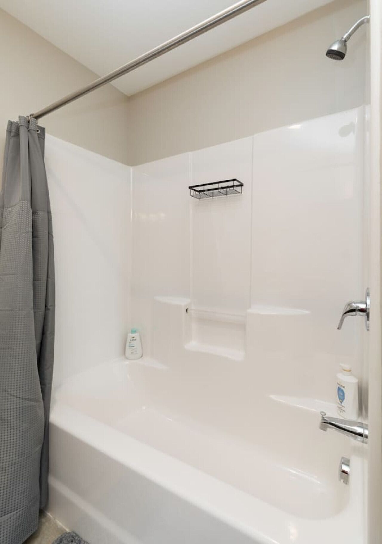 Un bagno moderno con una vasca da bagno bianca, una doccia e un porta asciugamani.