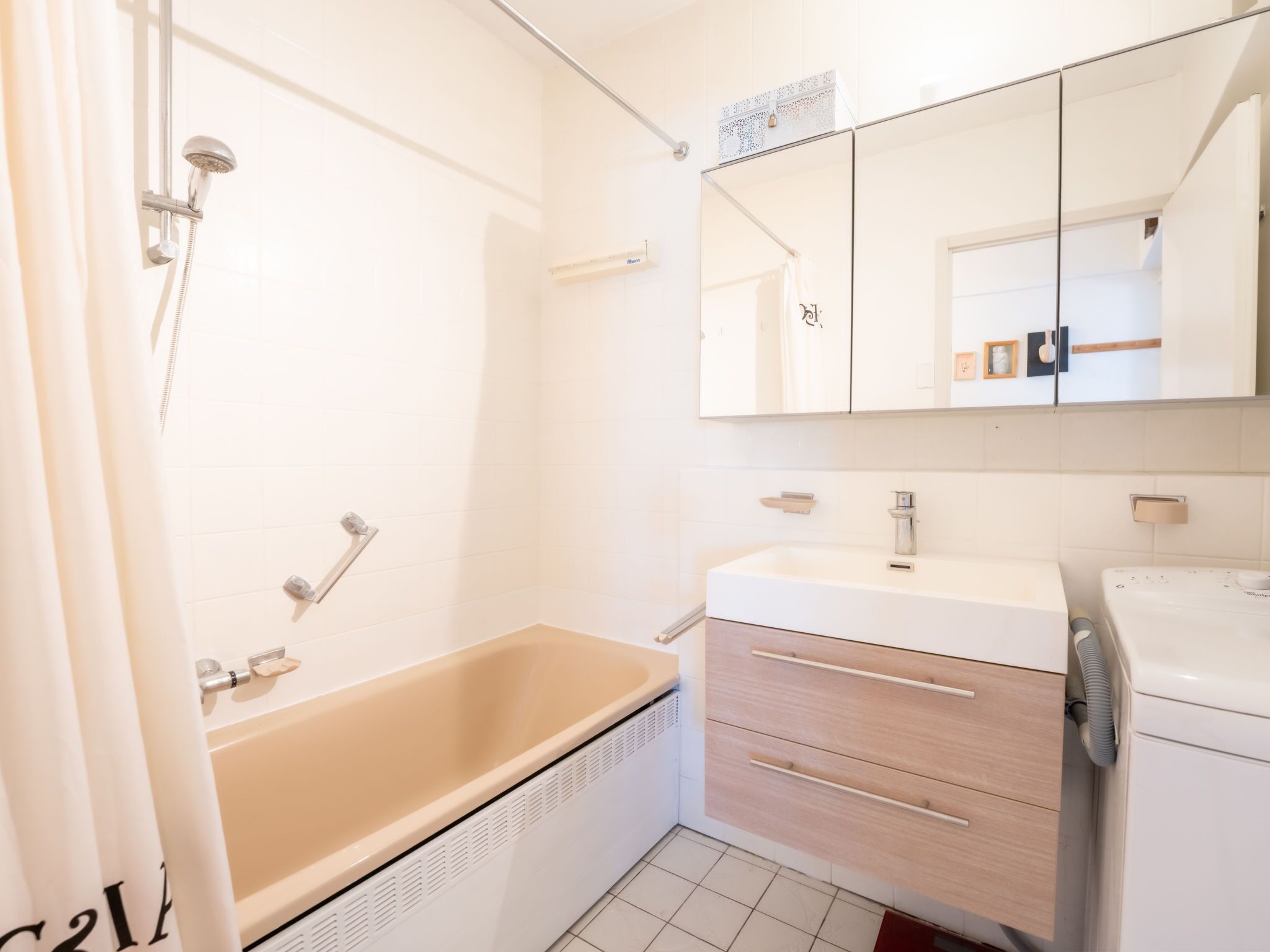 A bathroom with a bathtub, a sink, a mirror, and a shower.
