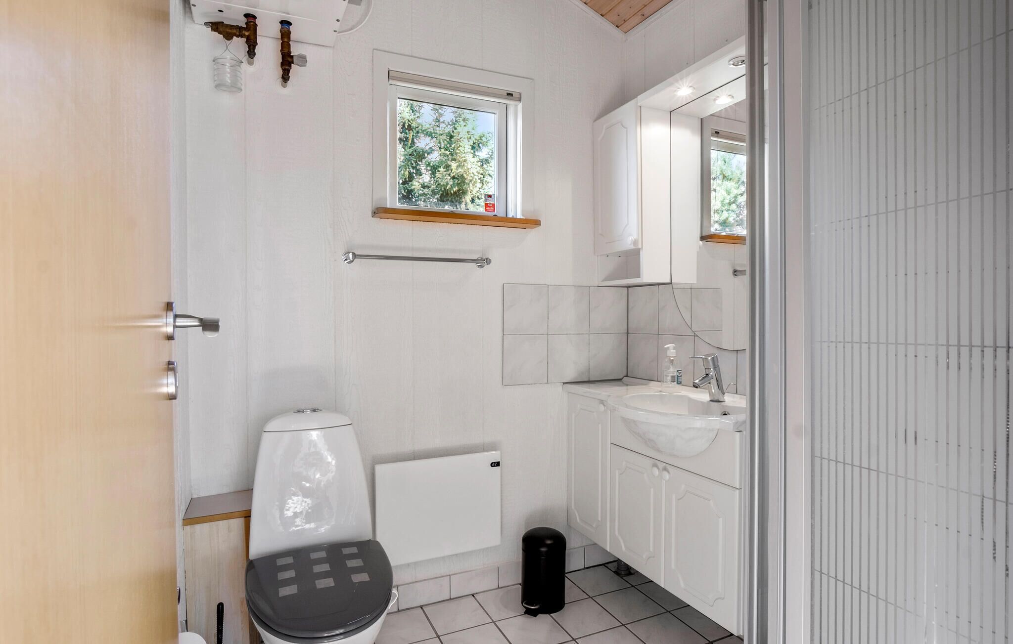 Un baño moderno con inodoro, lavamanos y ventana.