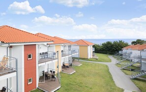 Enjoy ocean views from your balcony with a wooden deck and outdoor seating area.