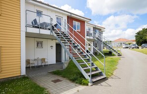 Stylish two-story buildings with outdoor seating areas and metal stairs leading to each entrance.