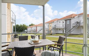 Enjoy a secure outdoor seating area with a table and chairs overlooking residential buildings with balconies.