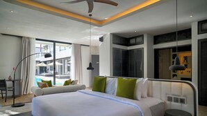 A modern hotel room with a large bed, a desk, and a view of the swimming pool. - CARPEDIEM VILLA BALI operated by Villa Nila (Canggu)