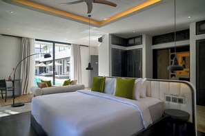 Une chambre d’hôtel moderne, dotée d’un grand lit, d’un bureau et offrant une vue sur la piscine.
