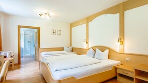 A hotel room with a large bed, bedside tables, a desk, and a shower area. - Apartment Nr. 18 by Interhome (Sulden)