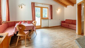 En matplats med ett träbord och stolar, en bänk och en soffa.
